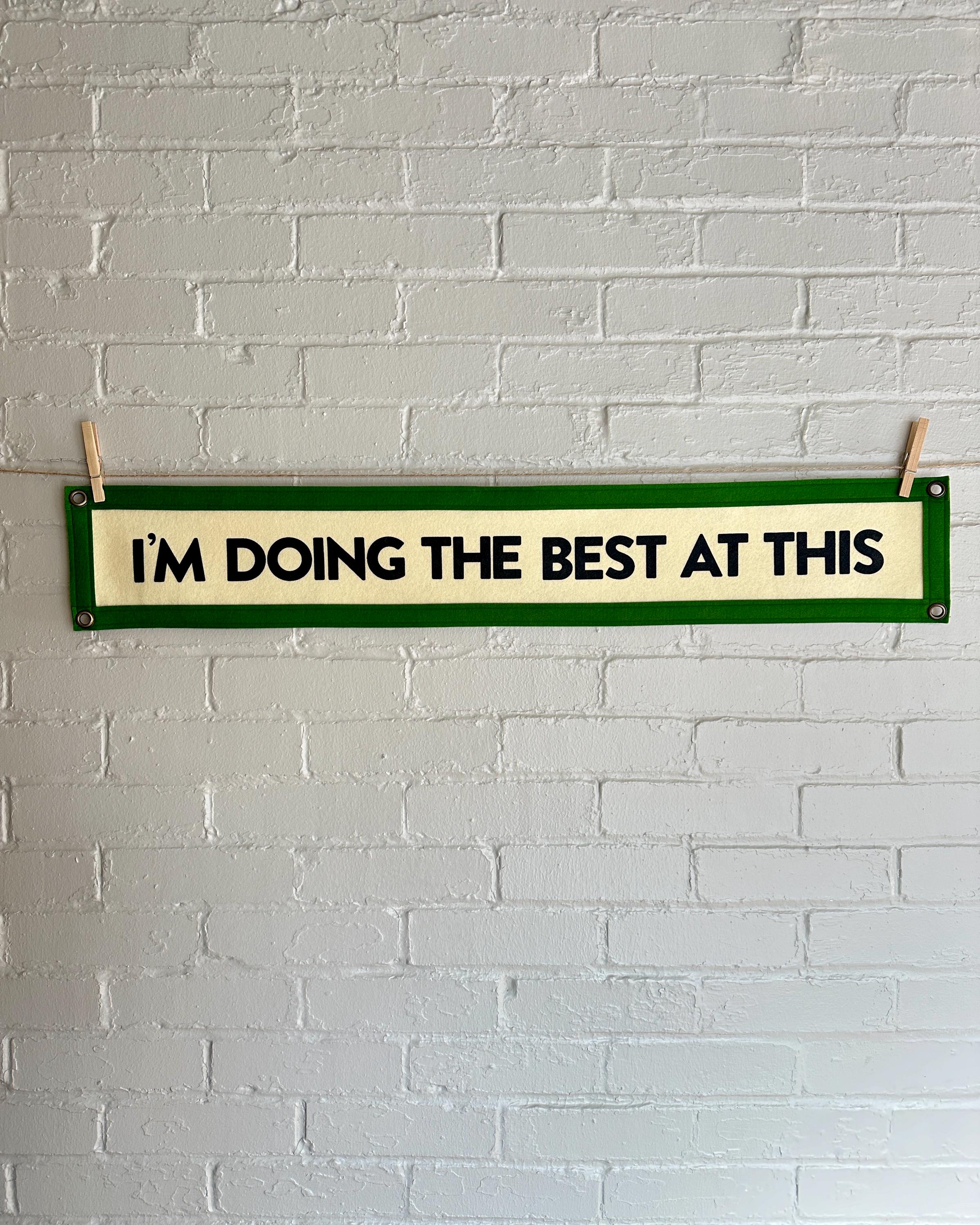 A cream banner with green trim and black lettering that reads "I'm doing the best at this"