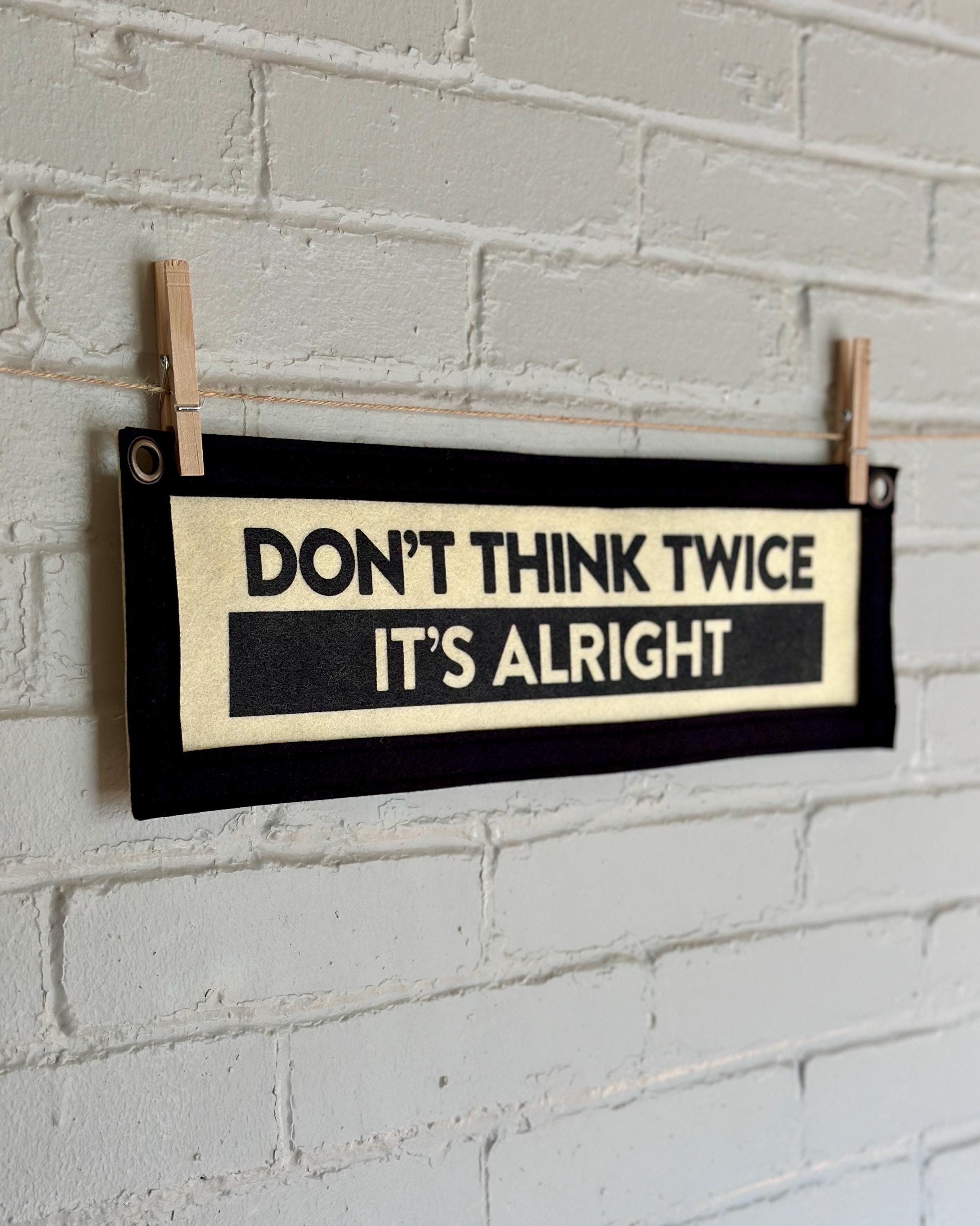 The side of a cream banner with black trim and lettering that reads "Don't Think Twice It's Alright"