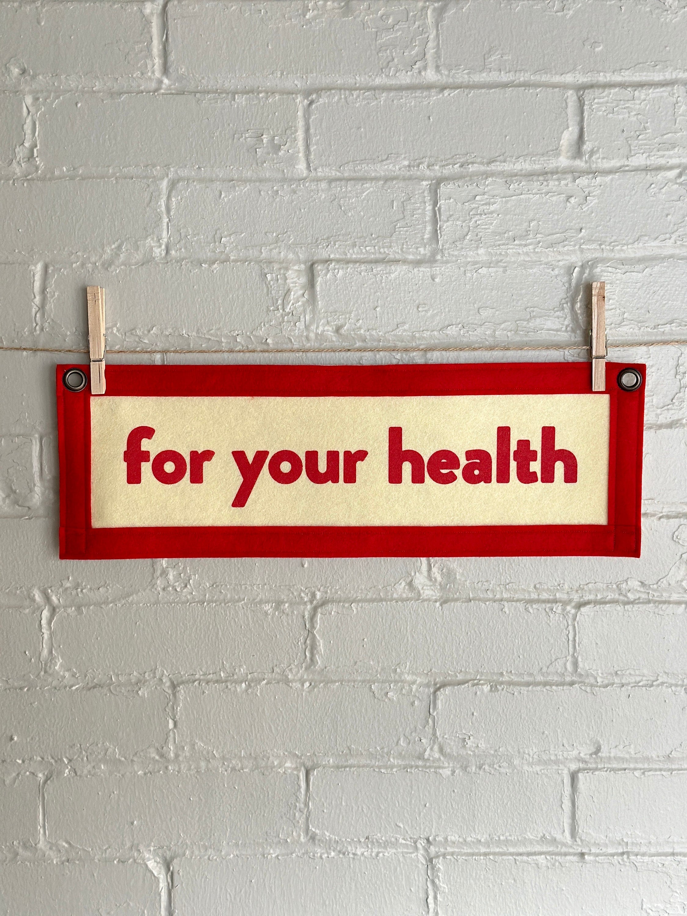 A cream banner with red felt trim and red lettering that reads "for your health"