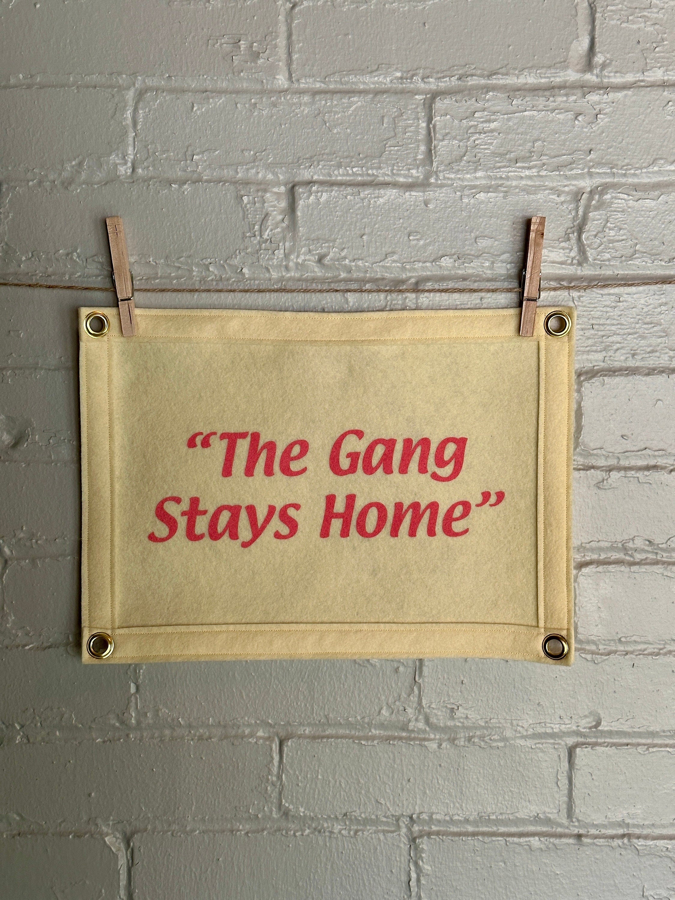 A cream banner with cream felt trim and pink lettering that reads "the gang stays home"