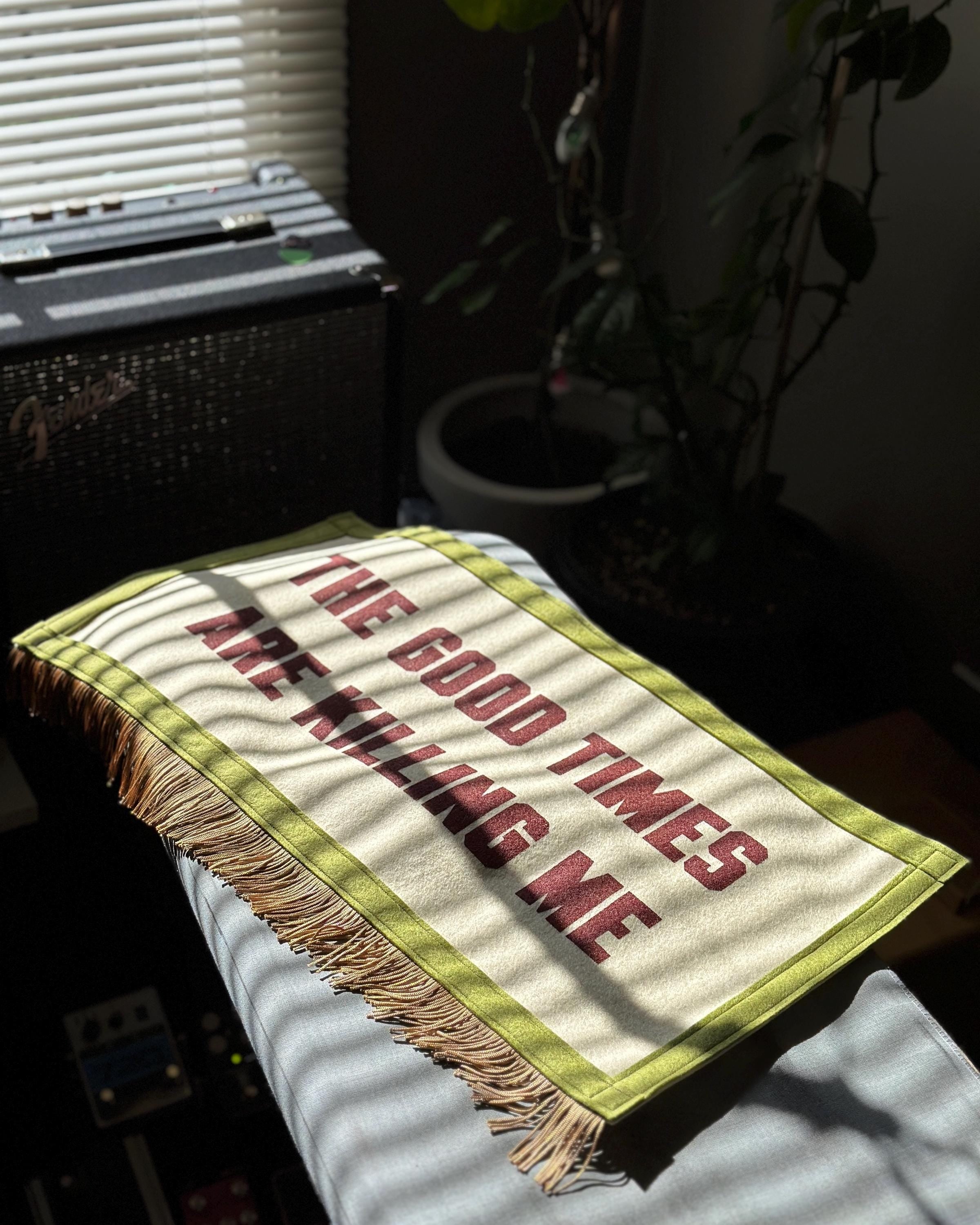 The Good Times felt banner on an ironing board with striped rays of sunshine coming through a nearby window