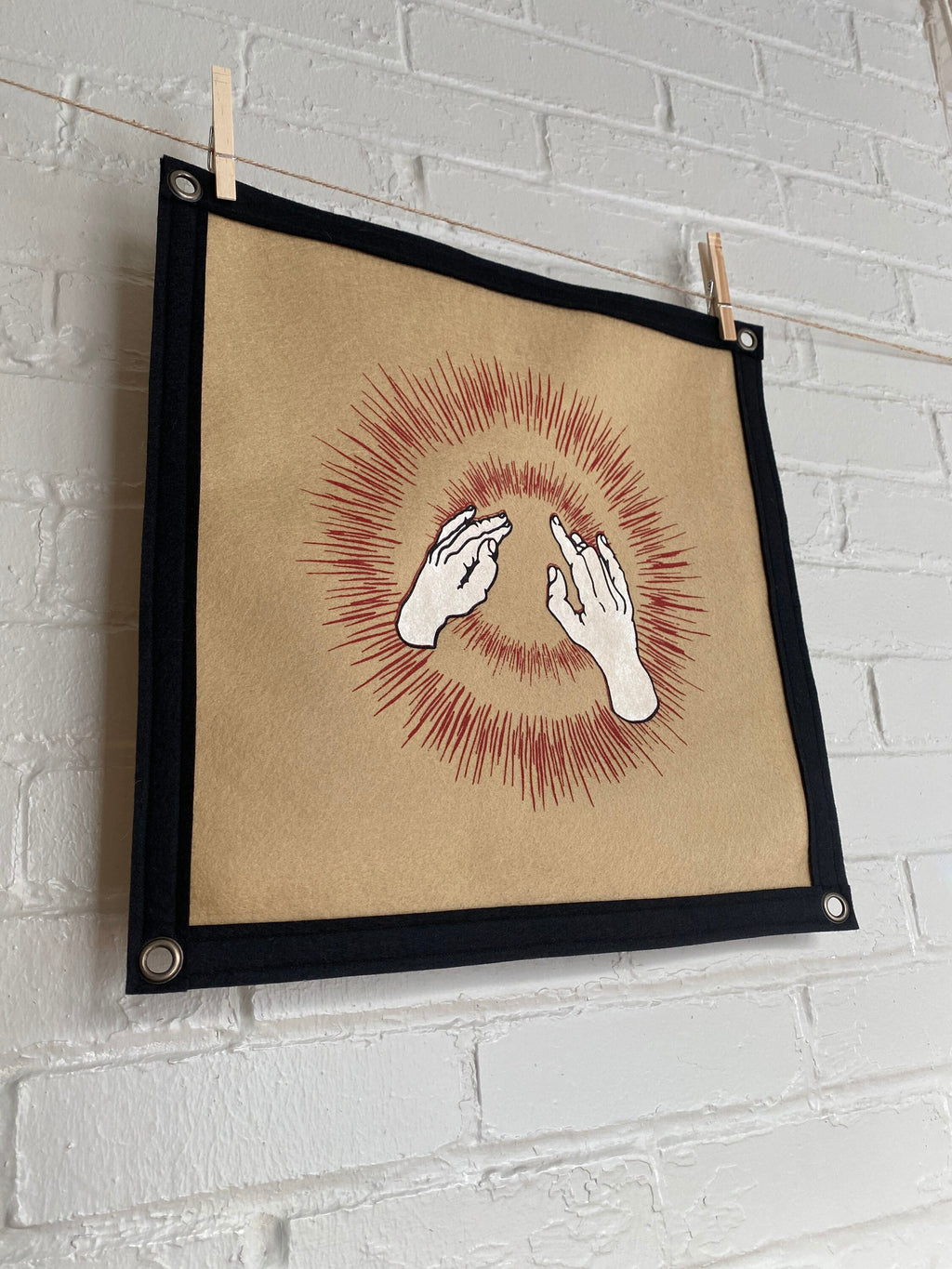 Side view of a light brown felt banner with black trim, and album art from band Godspeed You! Black Emperor