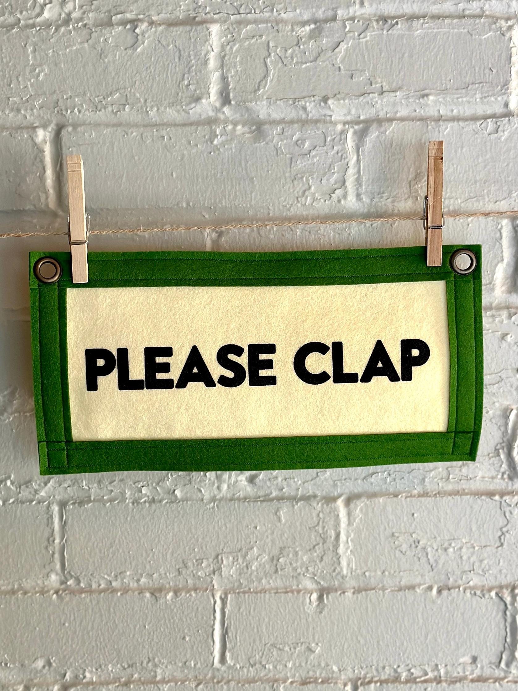 Cream felt banner with green trim and black lettering that reads "PLEASE CLAP"