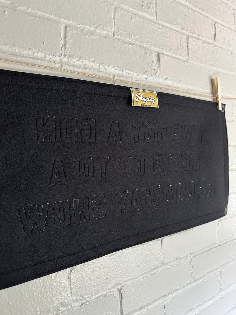 The back of a black banner with applique letters and a Payday Custom Shop tag showing