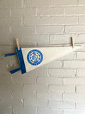 A white felt pennant with light blue trim and the OSI logo from the cartoon The Venture Bros printed in blue ink