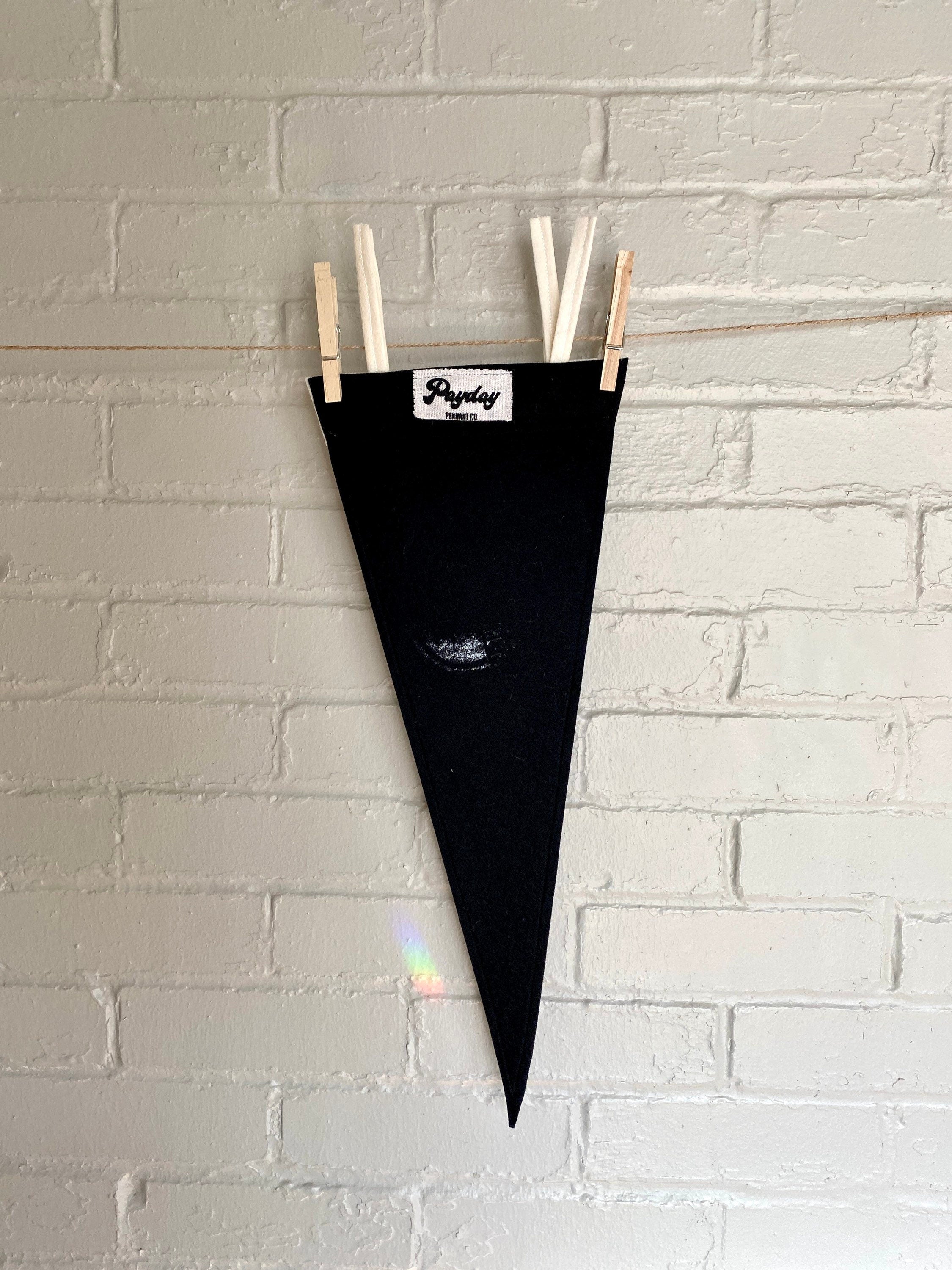 The back of a black pennant with white trim and the Venture Bros "Black Hearts" logo printed on