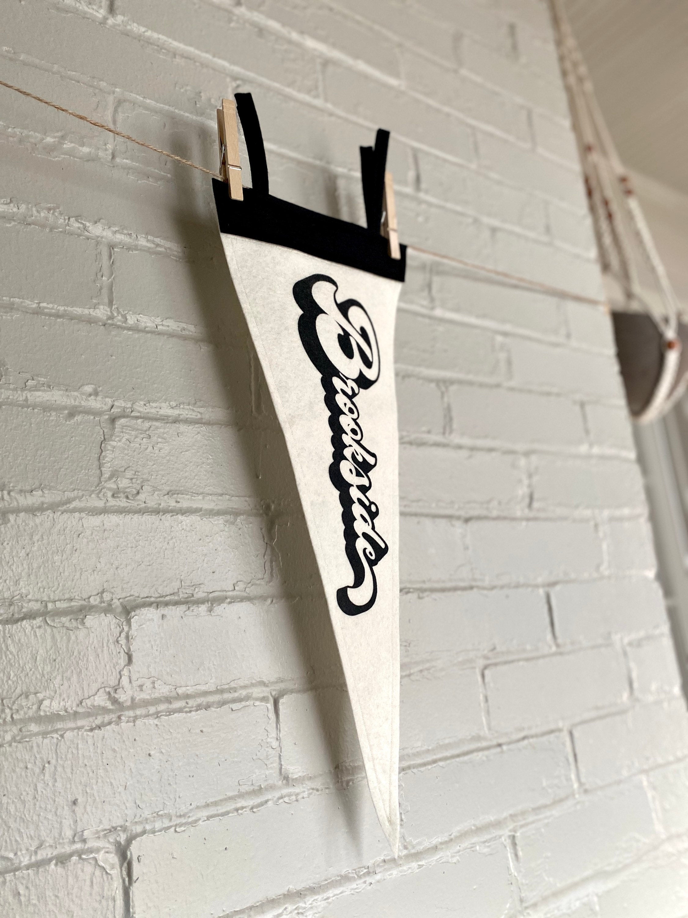 A side view of a black and white pennant and "Brookside" printed on